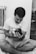 a man sitting on a bed holding a baby