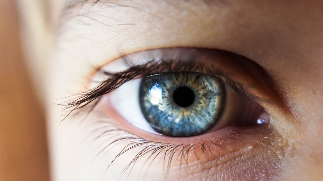 person opening his right eye with blue iris,