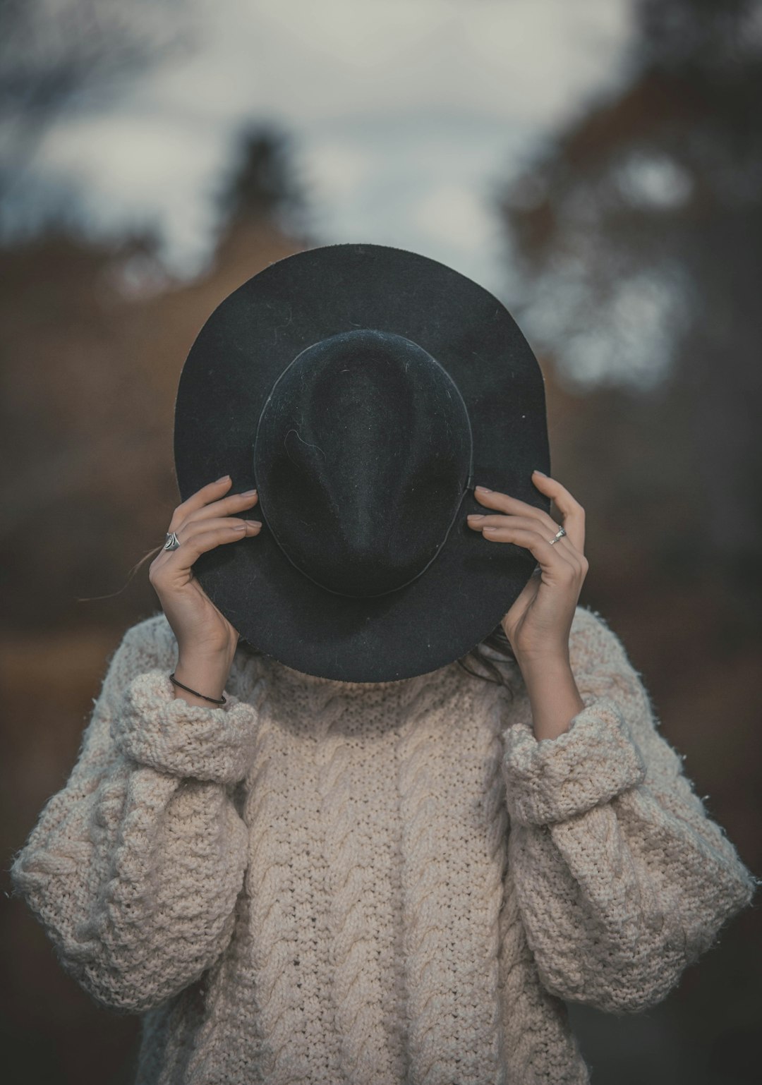 woman holding black hat