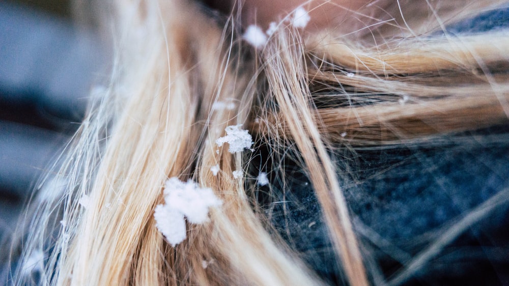 a close up of a woman with snow flakes on her hair