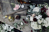 Close-up of delicate floral arrangements in soft pastel tones adorning a rustic wooden table.
