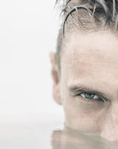 Close-up of a swimmer's focused face mid-stroke in the water.