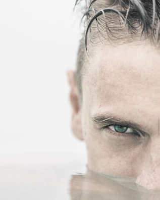 Close-up of a swimmer's focused face mid-stroke in the water.