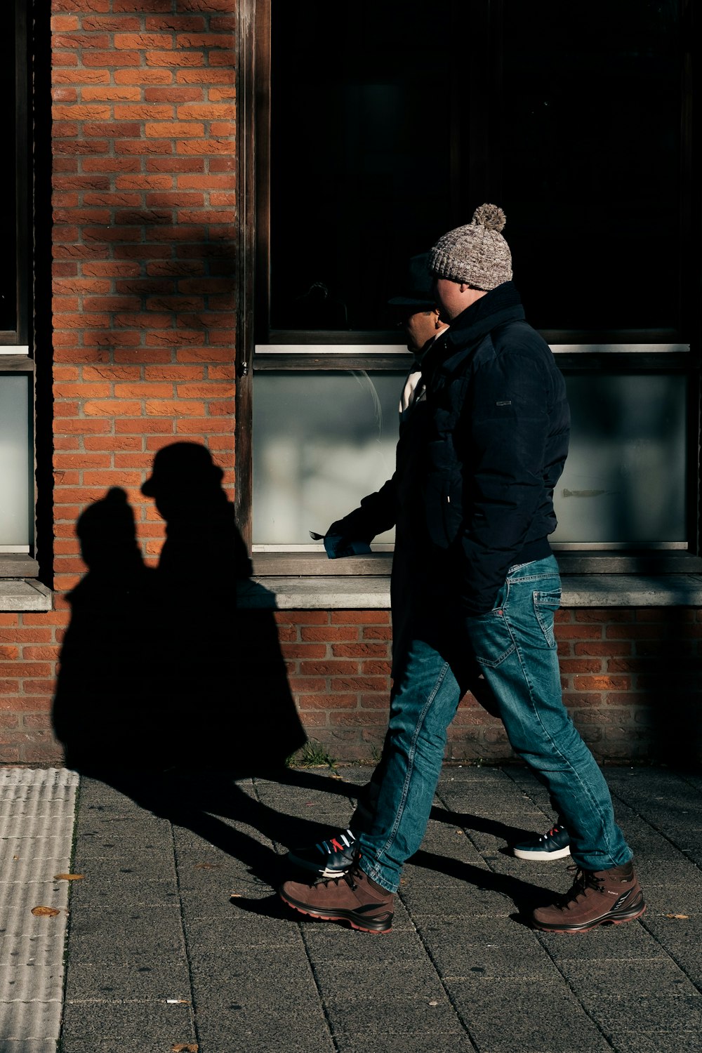 two people walking on sidewalk