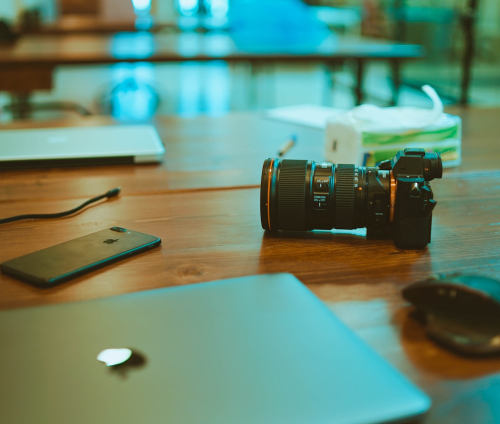 black iPhone 7 Plus and DSLR camera on table