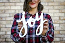 woman holding joy text