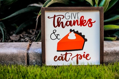 give thanks and eat pie poster with brown frame on green grass field thankful teams background