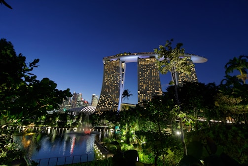 A stunning nighttime view of Burj Khalifa towering over a lush green Dubai compound.