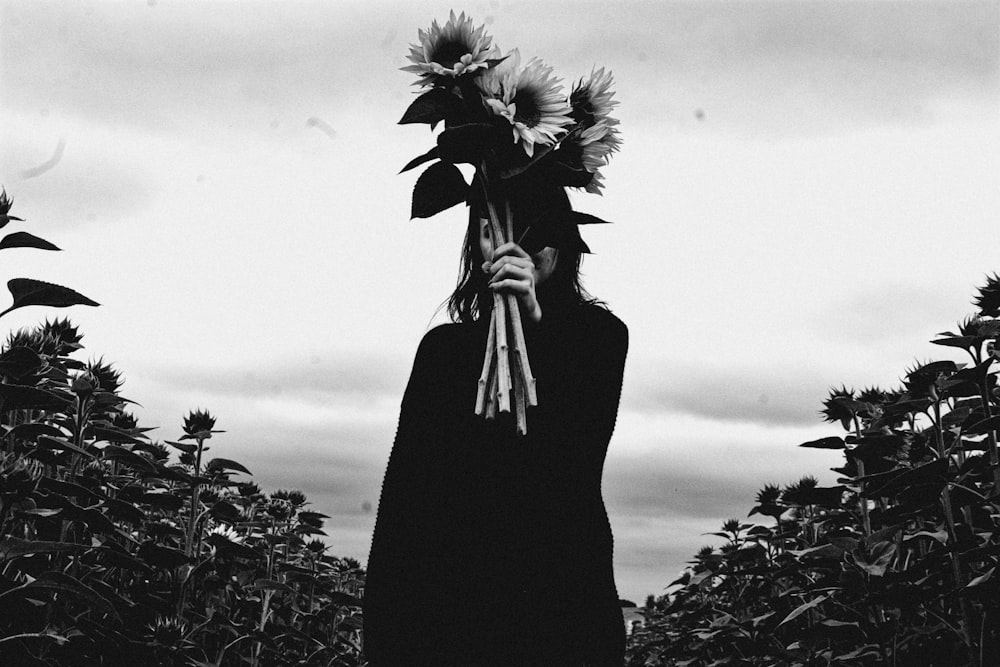 person holding sunflower grayscale photography