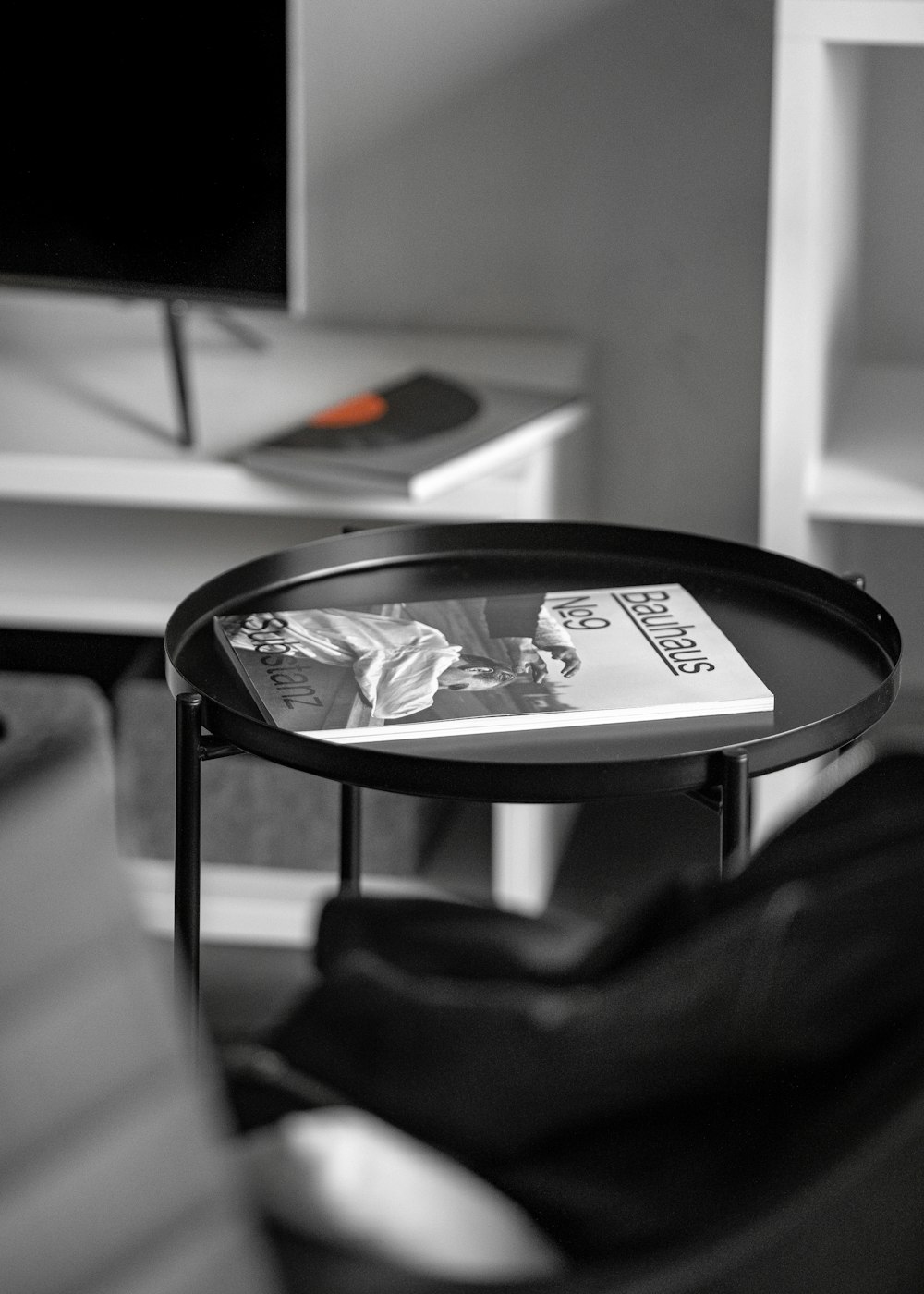 round black metal end table with magazine on top