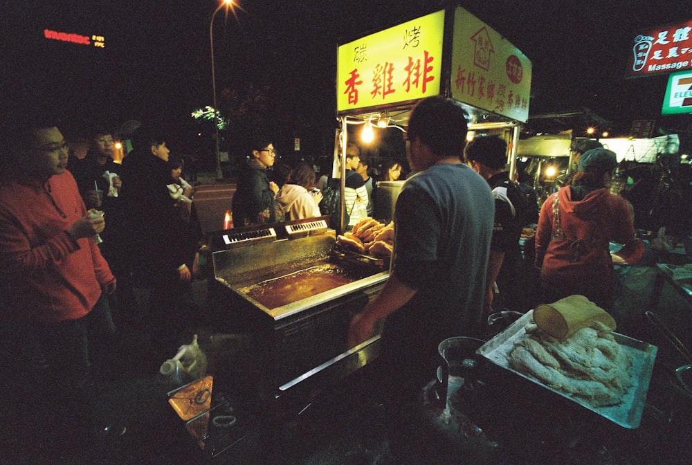 people standing near food stall