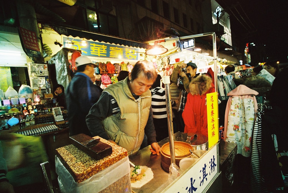 man preparing food on food stall with light bulb