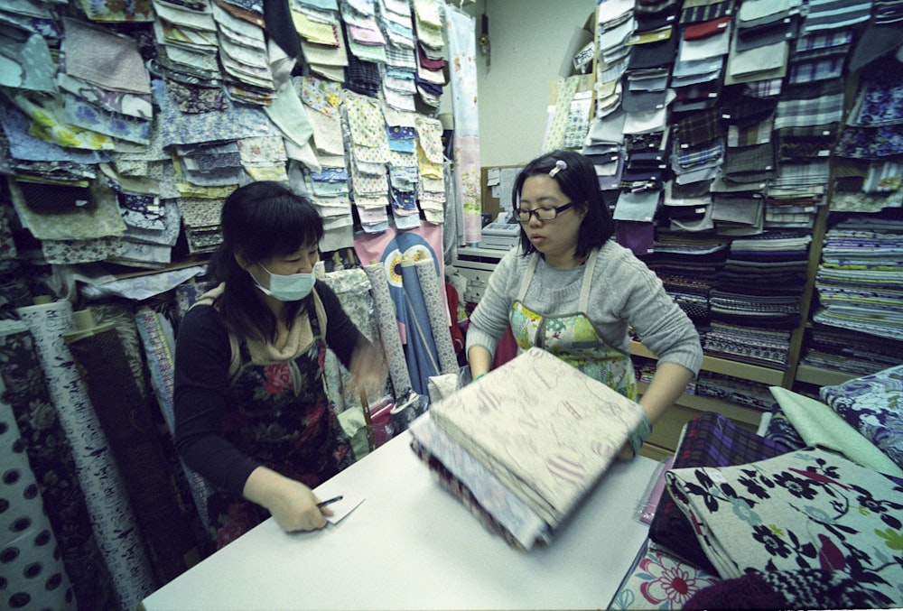 two women holding textiles