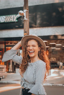woman holding brown hat