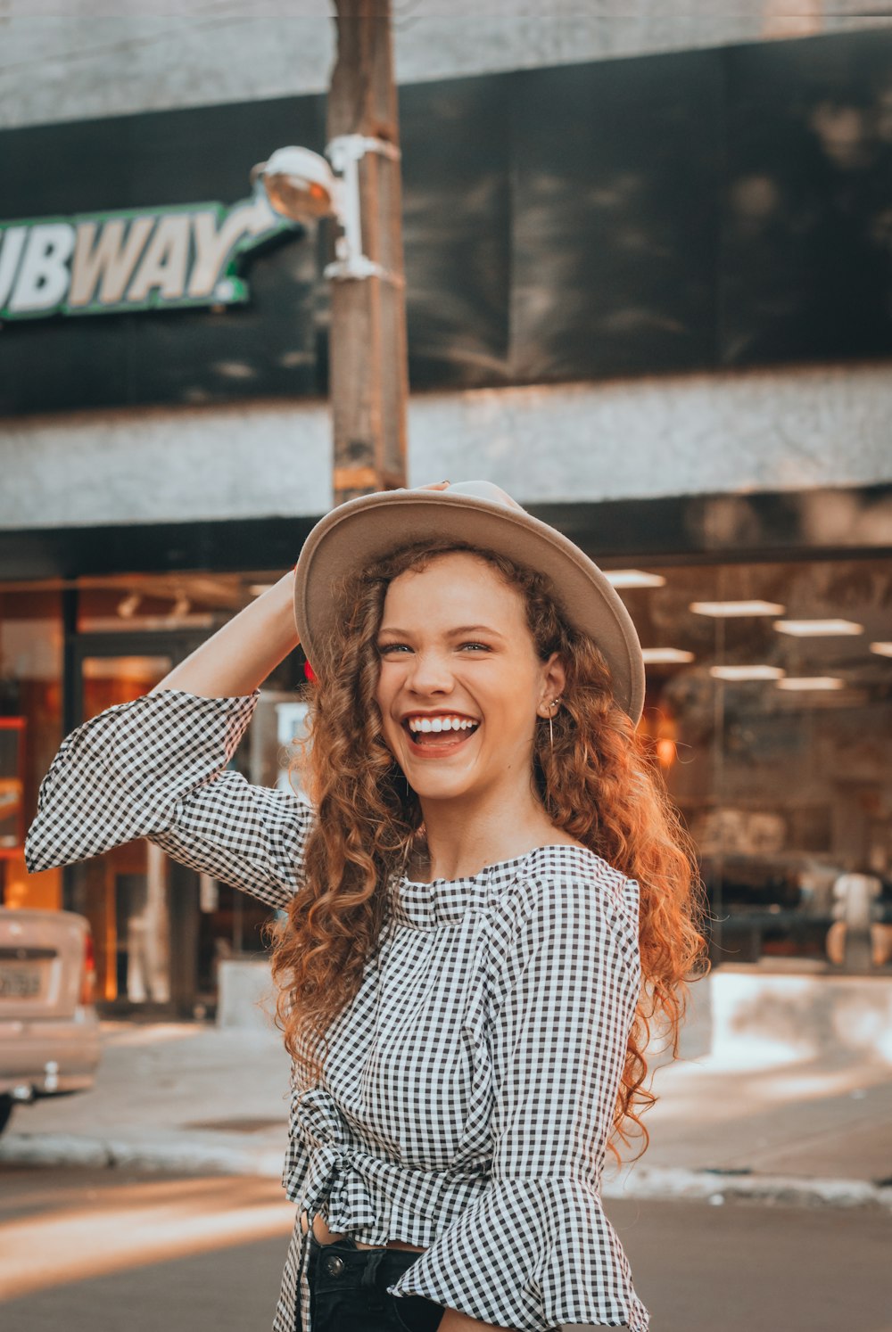 woman holding brown hat