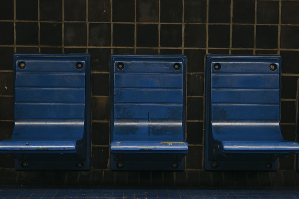 three gray metal chairs against wall