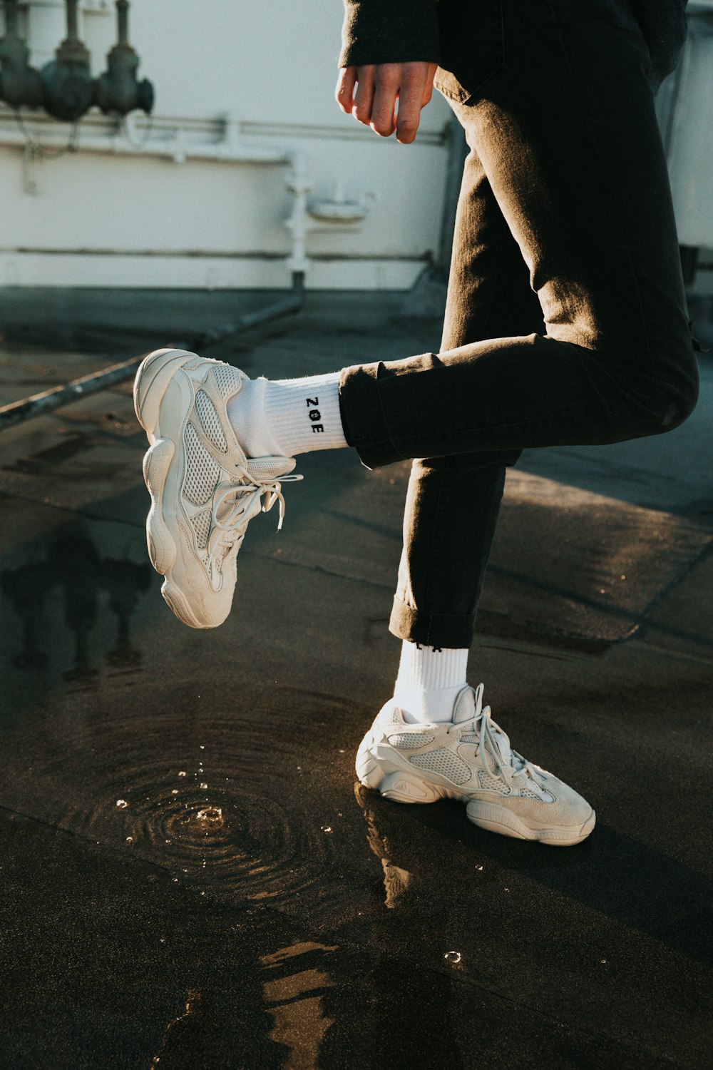 person wearing black pants, white socks, and low-top sneakers