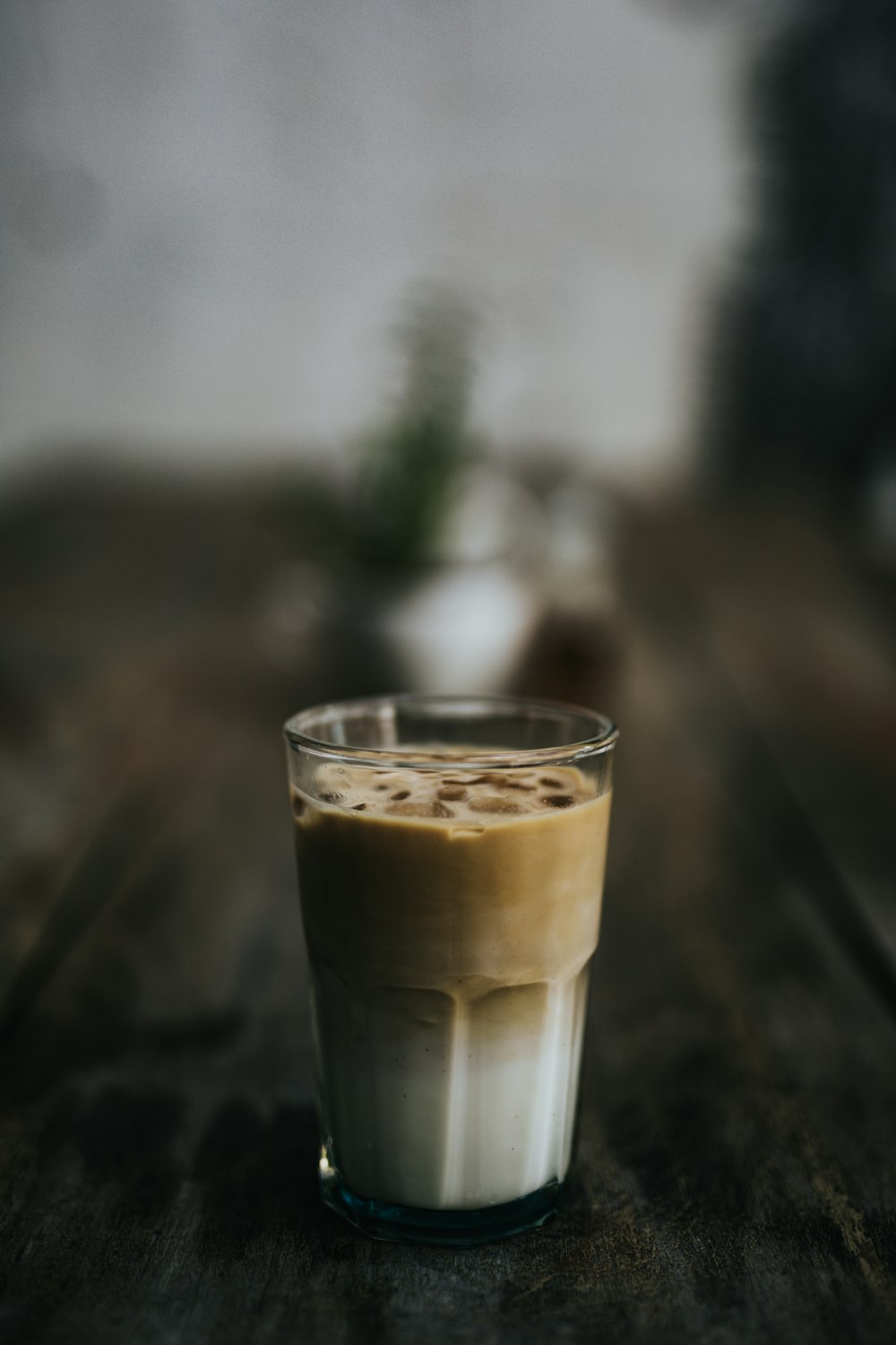 brown and white beverage on clear glass cup