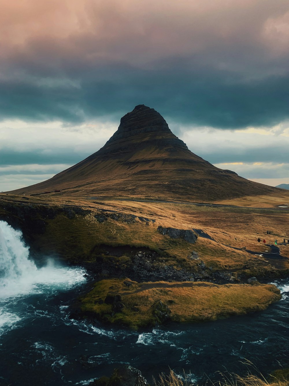 mountain near water coast under cloudy sky