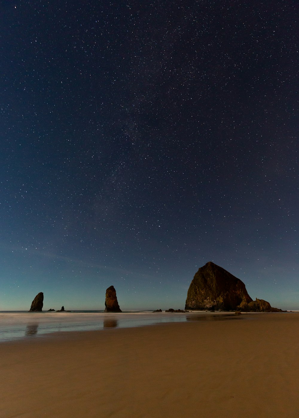 rock formation near shore under starry sky