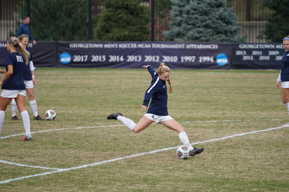 girl trying to kick soccer ball during daytime