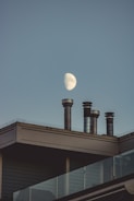 view of the moon on the sky and chimneys