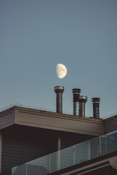 view of the moon on the sky and chimneys