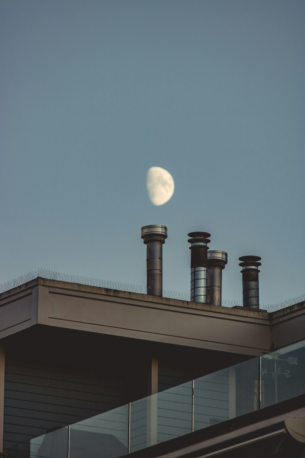 view of the moon on the sky and chimneys