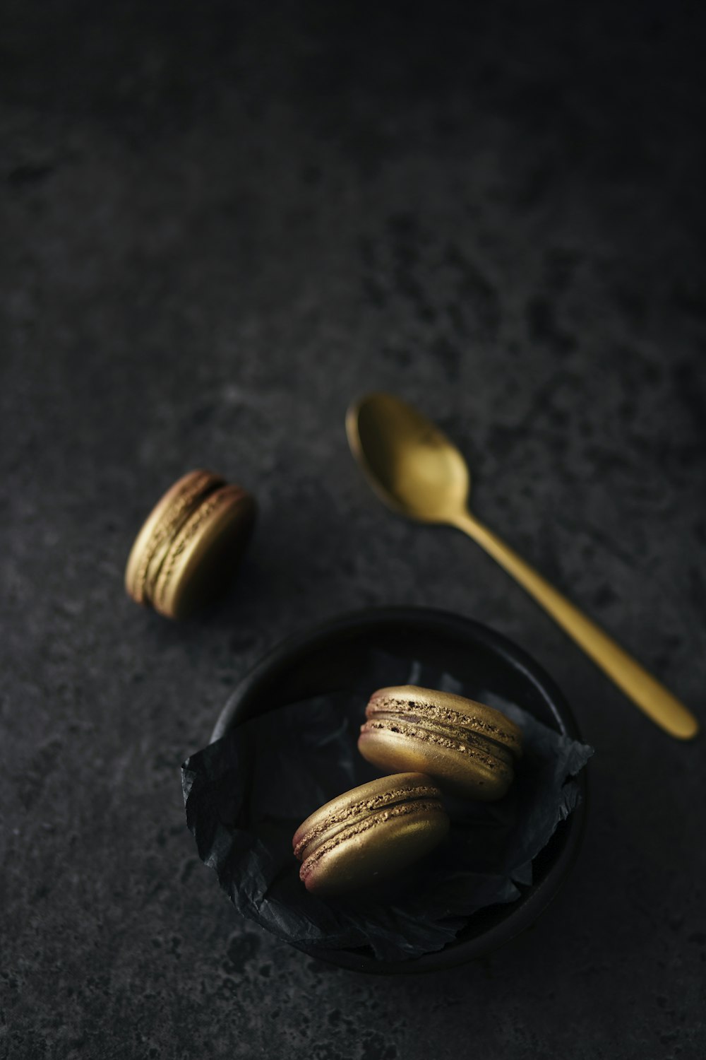 three macaroons on black bowl