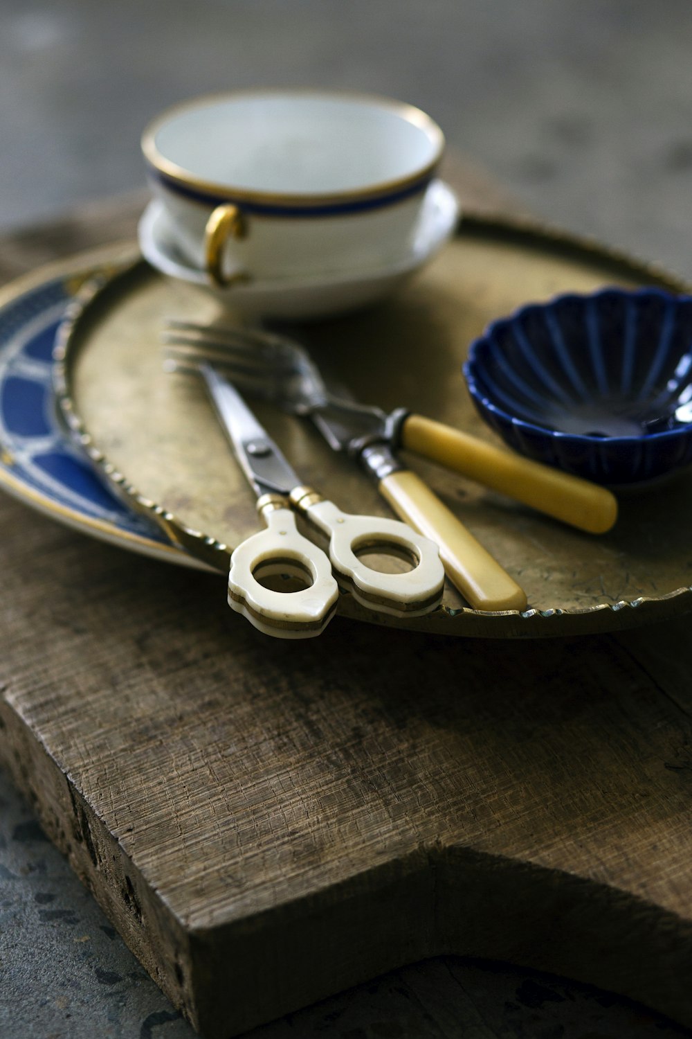 brown handled scissors beside fork and knife on plate