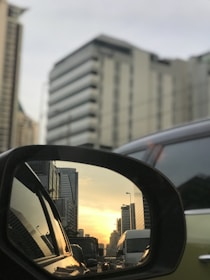 An image of a stylish car mirror reflecting a vibrant cityscape, emphasizing modern design.