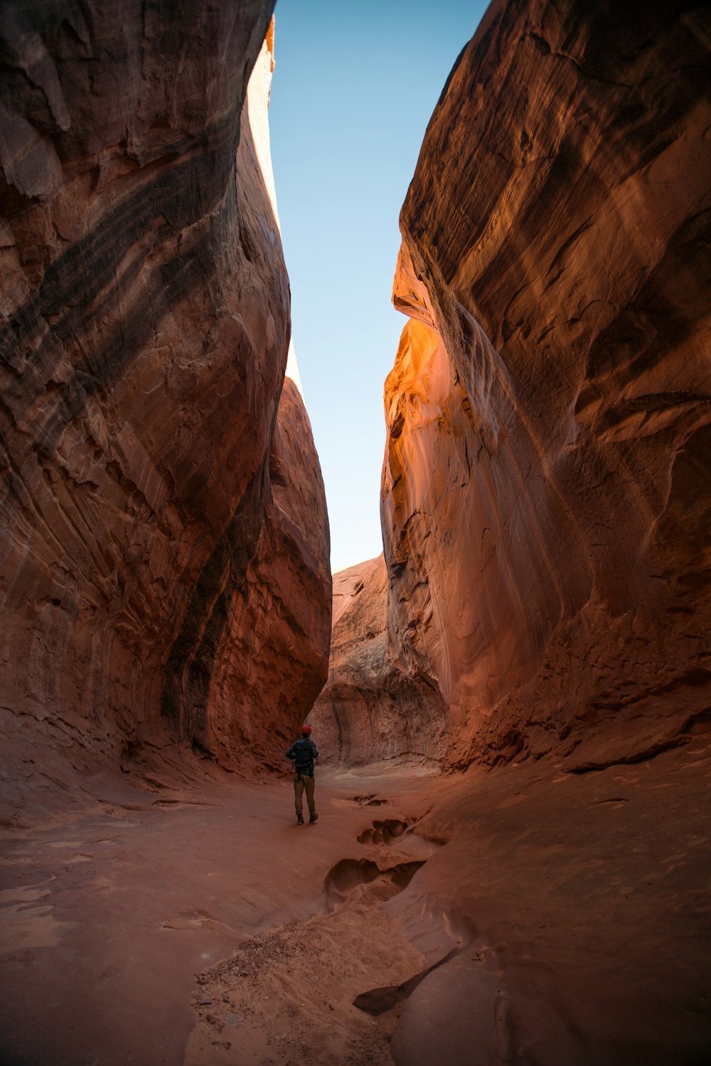 man standing in middle of rock formation during daytime
