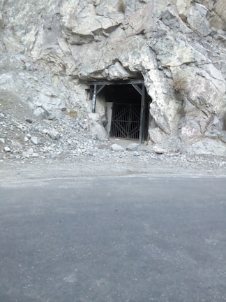 An underground bunker entrance discreetly integrated into a hillside with sturdy steel doors.