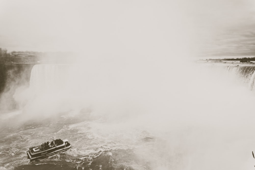 a boat in a body of water near a waterfall