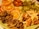 A plate filled with a colorful array of dried fruits, including orange slices, apple chips, kiwi slices, figs, banana chips, and sweet potato slices, all arranged in an appealing manner.