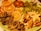 A plate filled with a colorful array of dried fruits, including orange slices, apple chips, kiwi slices, figs, banana chips, and sweet potato slices, all arranged in an appealing manner.