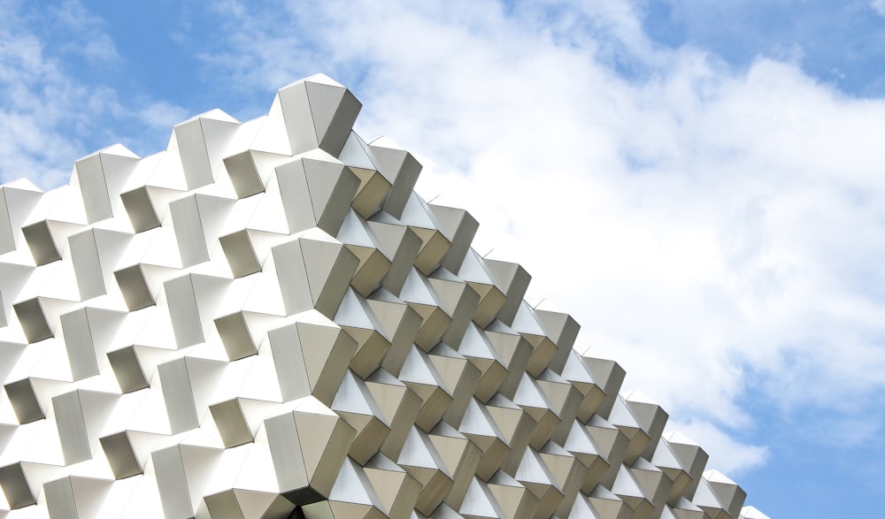 Low-Angle-Foto eines weißen Betongebäudes unter klarem blauem Himmel