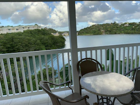 Close-up of a cozy balcony overlooking lush greenery and calm waters.