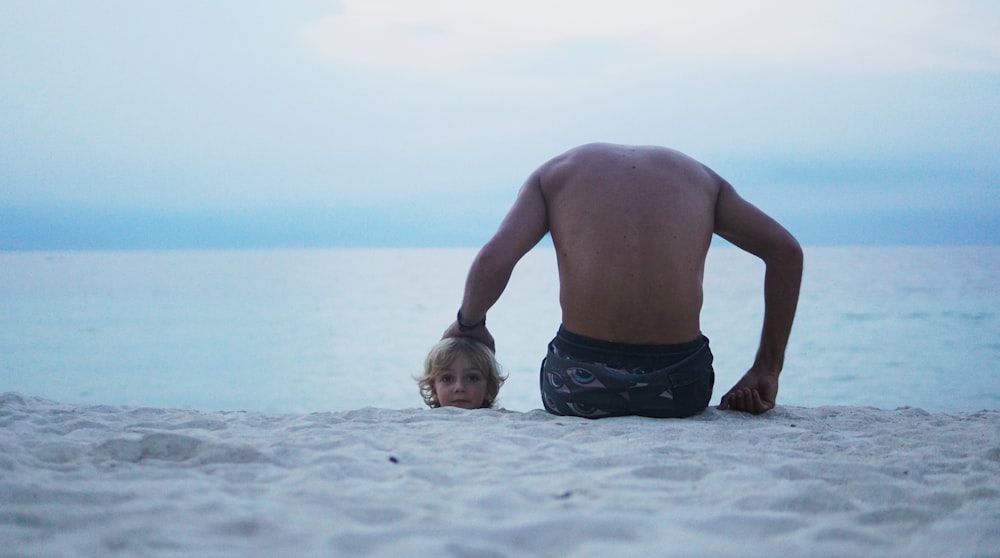 man sitting on seashore