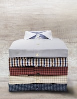 An array of neatly folded shirts featuring distinct patterns and colors.