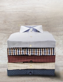 Close-up of vintage men's shirts neatly folded on a wooden table.