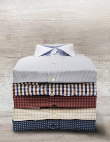 A stack of folded flannel shirts with a corrugated metal backdrop.
