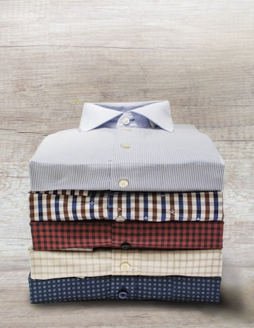 Flat lay of three patterned t-shirts arranged neatly on a rustic wooden table