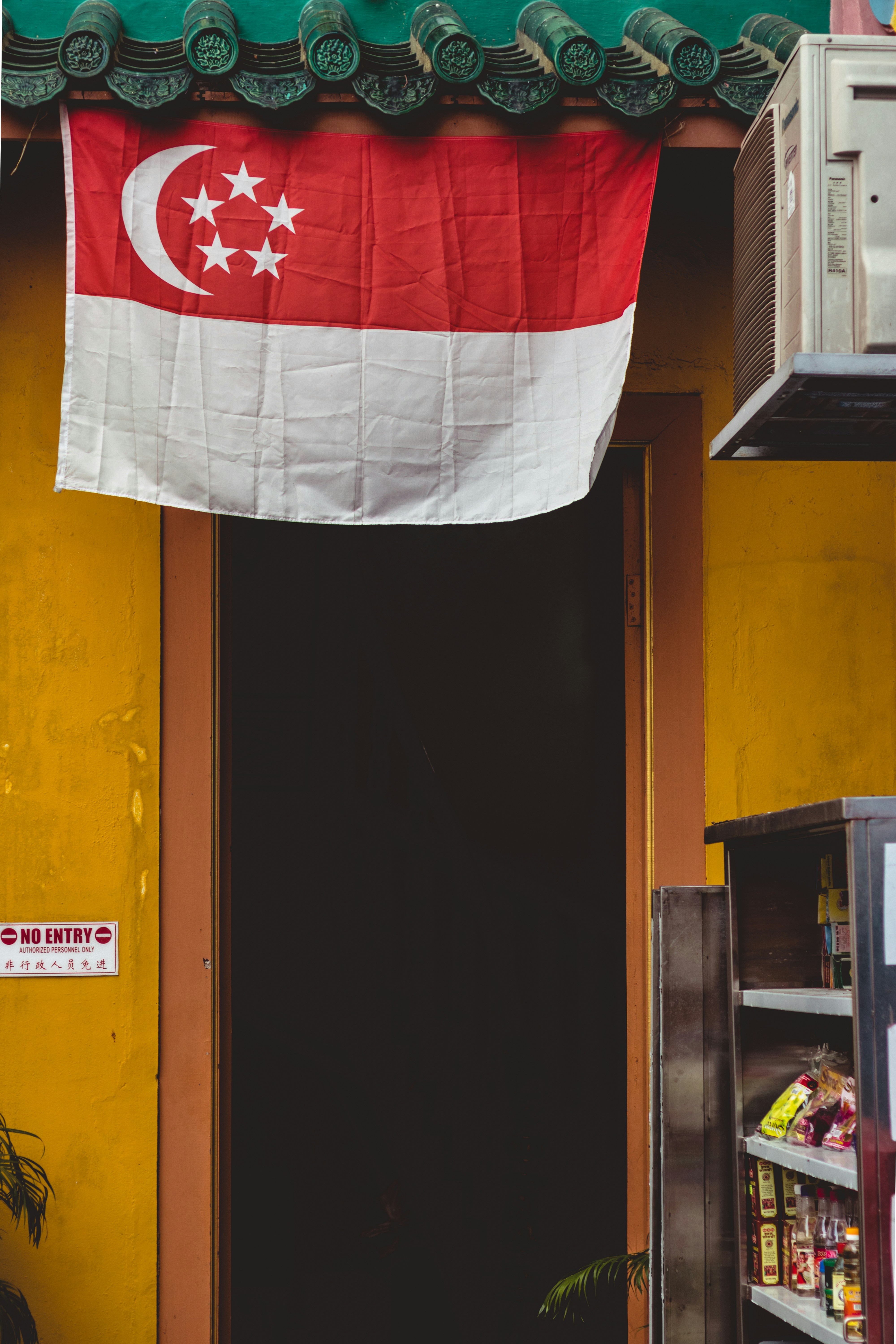 Singapore flag hung over a traditional building.
