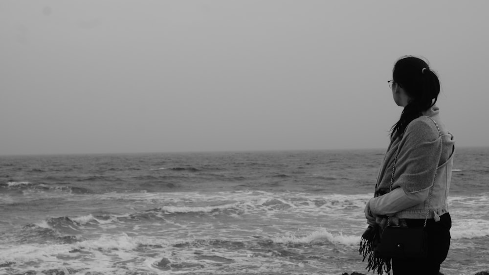 standing woman near sea during daytime