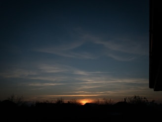 A peaceful sunset over the hills of Álvaro Obregón, with silhouettes of trees.