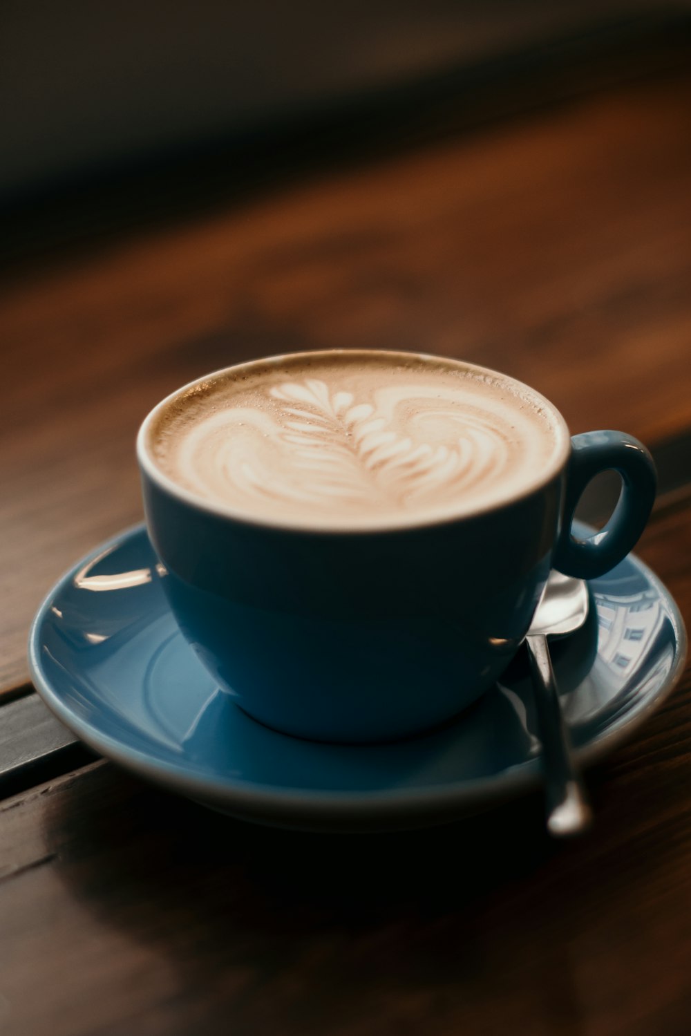 blue ceramic teacup set filled with cappuccino on table