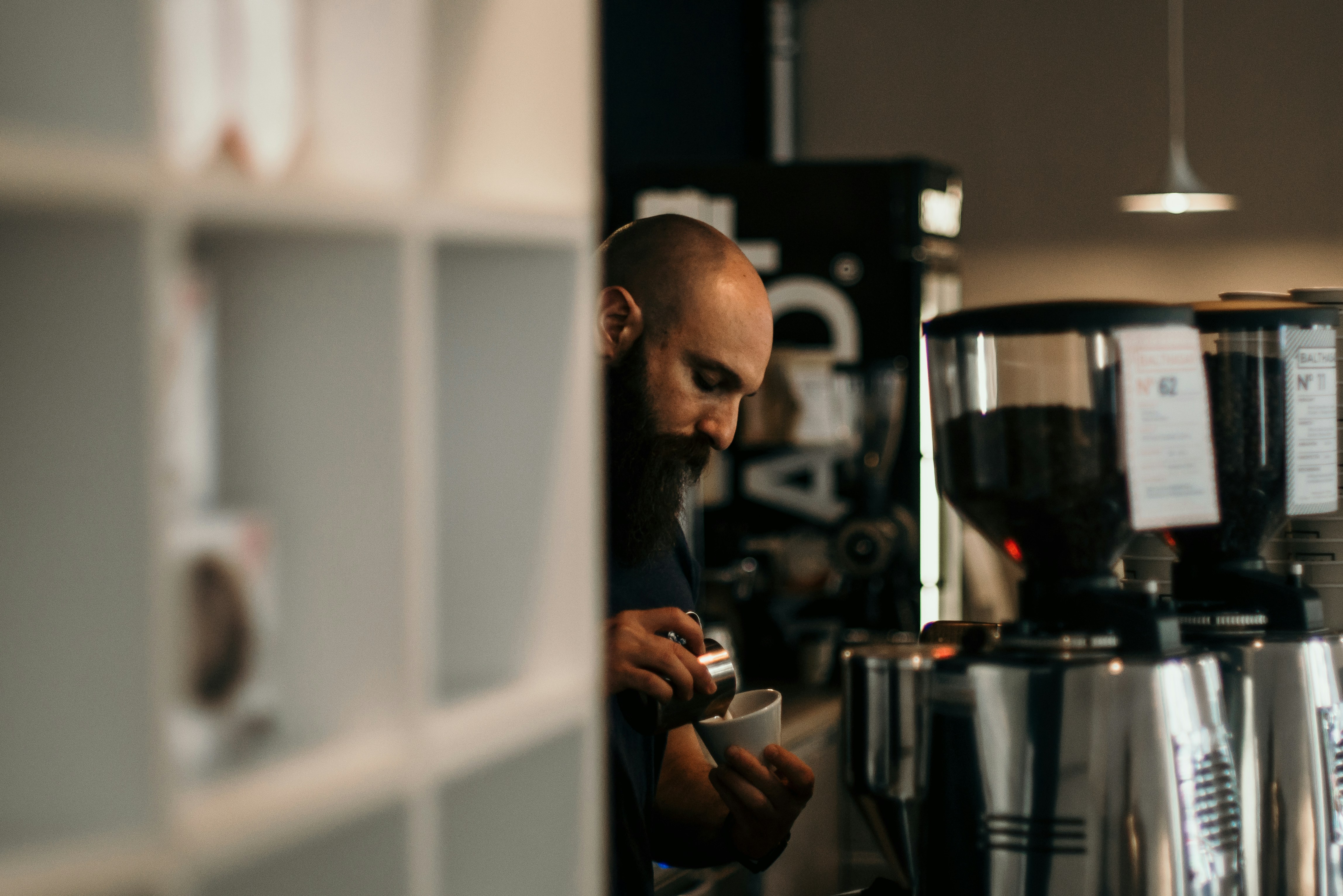 man pouring coffee on teacup