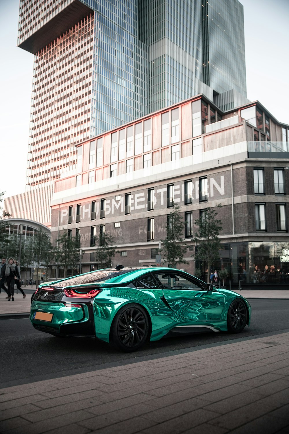 green supercar parked on sidewalk