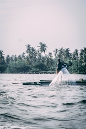 Fisherman casting a line into the calm waters of Río Frío surrounded by dense flora.
